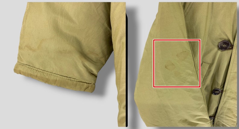 Puede incluir: Primer plano de una chaqueta caqui. La chaqueta tiene cierre de botones y un bolsillo. El pu&ntilde;o de la manga es visible. La tela presenta algunas manchas. La chaqueta parece estar hecha de un material ligero.