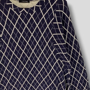 May include: Navy blue long-sleeve shirt with a white diamond pattern. The shirt has a crew neck and the text "Yf for living" is visible on the neckline.