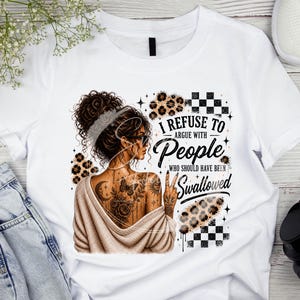 Può includere: T-shirt bianco con un design grafico raffigurante una donna con tatuaggi e occhiali da sole, la scritta "I REFUSE TO argue with PEOPLE who should have been SWALLOWED" e dettagli animalier. La maglietta è abbinata a jeans blu e scarpe da ginnastica bianche.