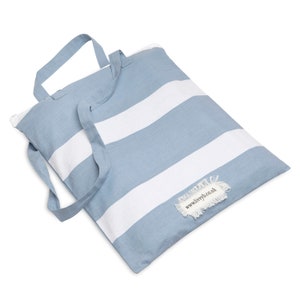 Puede incluir: Una bolsa de mano de rayas azules y blancas con cierre de cremallera y una etiqueta deshilachada que dice "www.livvyb.co.uk".