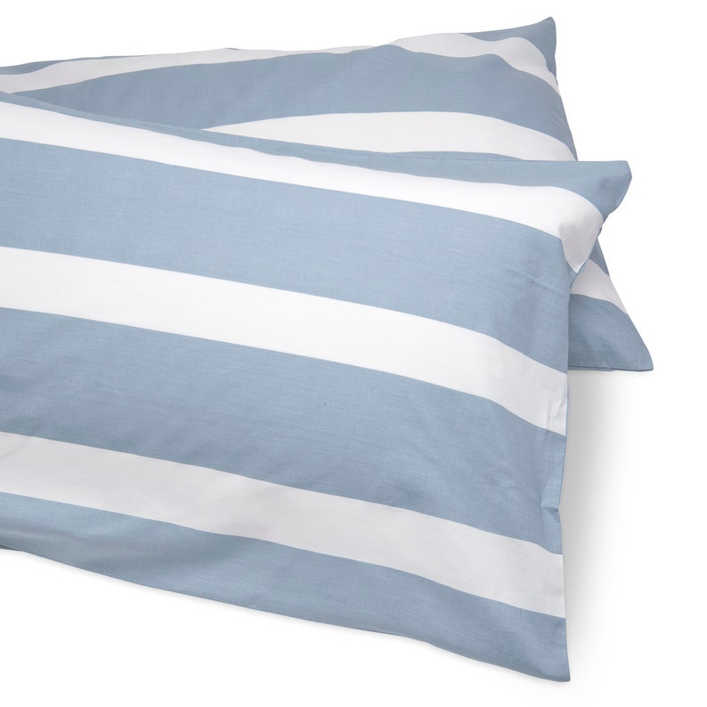 Puede incluir: Dos fundas de almohada a rayas azules y blancas. Las fundas de almohada est&aacute;n hechas de una tela suave y c&oacute;moda y tienen un brillo sutil.