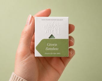 May include: A square white cardboard box containing hand-poured scented wax melts. The packaging features the embossed text "make me melt" and a green label with the white printed text "Green Bamboo" and "Luxury Soy Wax Melts".