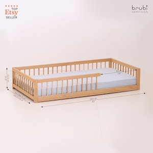 May include: A natural wood toddler bed with a light blue mattress. The bed frame has a slatted design and measures 65 inches long, 24 inches wide, and 12.5 inches high. The bed is designed for children.