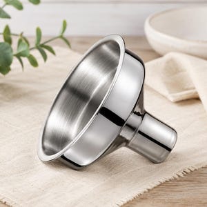 May include: A polished silver-colored metal funnel with a wide, circular top opening and a narrow, cylindrical stem. The interior surface features a brushed texture, while the exterior has a smooth, reflective finish that catches the light.
