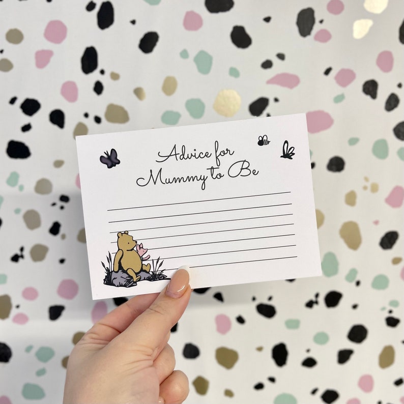 May include: A white card with black text that reads "Advice for Mummy to Be". There is a small illustration of Winnie the Pooh sitting on a rock with a pink flower. There are also small illustrations of butterflies and bees.