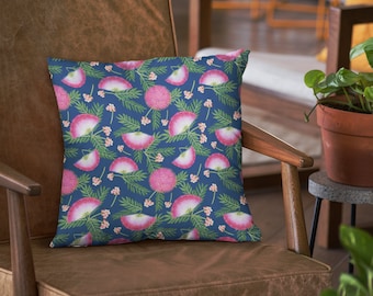 Puede incluir: Una almohada azul con un patrón floral rosa. La almohada está sentada en una silla de cuero marrón.
