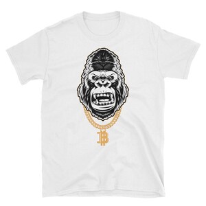 May include: A white t-shirt with a black and white illustration of a gorilla wearing a gold chain with a bitcoin pendant.