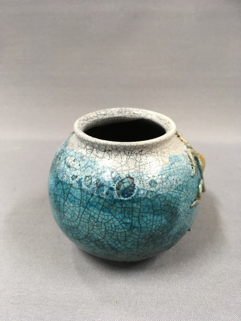 Octopus crawling around a pot vase