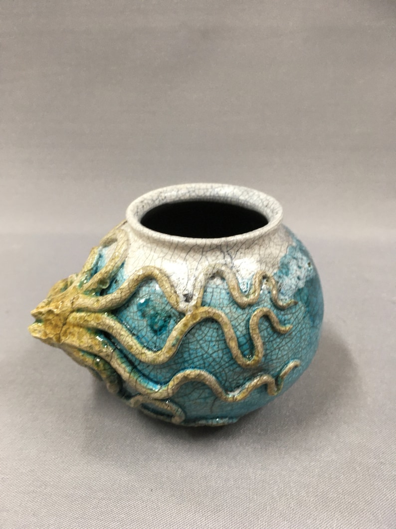 Octopus crawling around a pot vase