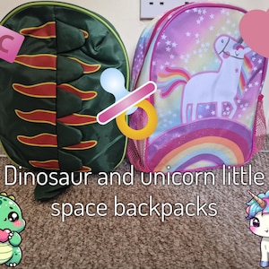 May include: Two children's backpacks. One is green with a dinosaur design and red accents. The other is pink with a unicorn, rainbow, and star design. Text on the image reads "Dinosaur and unicorn little space backpacks."