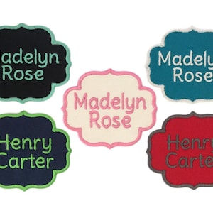 May include: Five embroidered iron-on patches with different names. The patches are in various colors, including black, white, teal, navy blue, and red. The names on the patches are "Madelyn Rose", "Henry Carter", and "Madelyn Rose".