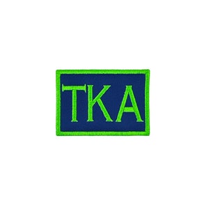 May include: A green and blue embroidered patch with the letters "TKA" in white.