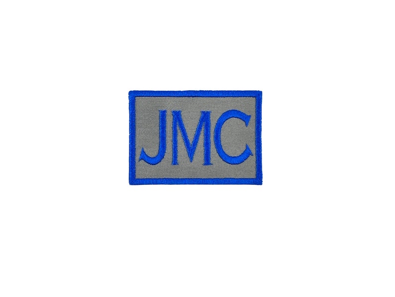May include: A gray rectangular patch with a blue border and the letters "JMC" embroidered in blue.