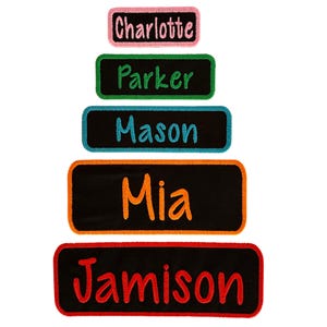 May include: Five black iron-on patches with different names in colorful embroidery. The names are Charlotte, Parker, Mason, Mia, and Jamison.