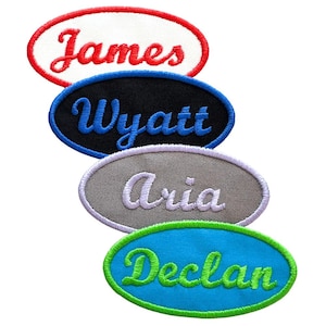 May include: Four oval-shaped embroidered patches with names in cursive script. The top patch is white with a red border and red text reading James. Below is a black patch with a blue border and blue text reading Wyatt. Then a gray patch with a light purple border and light purple text reading Aria. The bottom patch is bright blue with a green border and green text reading Declan.
