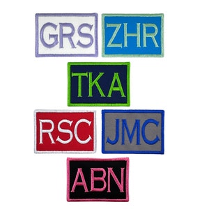 May include: Six embroidered patches with different colored backgrounds and white lettering. The patches spell out the words "GRS", "ZHR", "TKA", "RSC", "JMC", and "ABN".