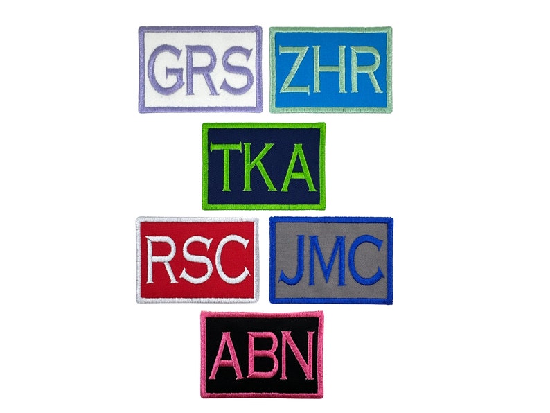 May include: Six embroidered patches with different colored backgrounds and white lettering. The patches spell out the words "GRS", "ZHR", "TKA", "RSC", "JMC", and "ABN".