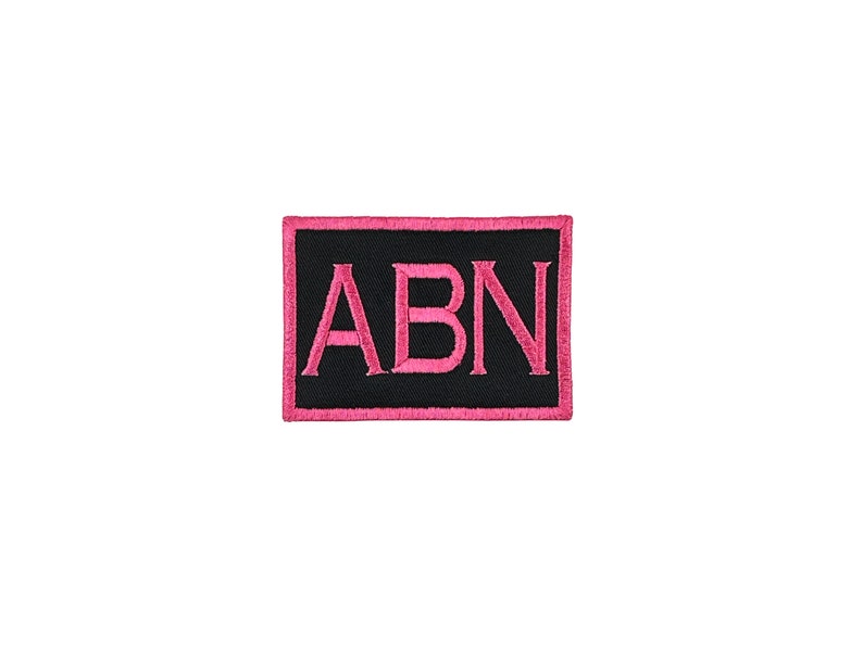 May include: A black rectangular patch with pink stitching. The letters "ABN" are embroidered in pink on the patch.