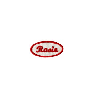 May include: White oval-shaped patch with a red embroidered border. The word "Rosie" is embroidered in red inside the oval.