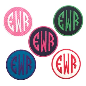 May include: Five round embroidered patches with the letters "EWR" in a circle. The patches are in different colors: pink with white polka dots, navy blue with pink letters, black with green letters, teal blue with purple letters, and white with red letters.