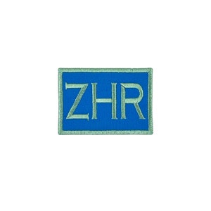 May include: A blue embroidered patch with a white outline and the text "ZHR" in a serif font.