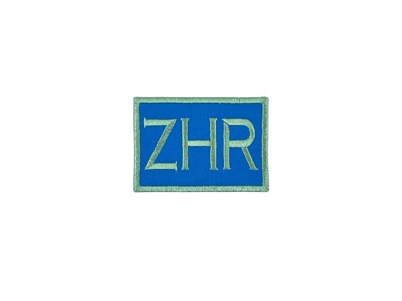 May include: A blue embroidered patch with a white outline and the text "ZHR" in a serif font.