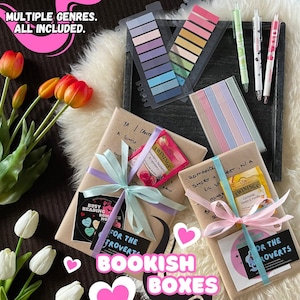May include: An overhead shot of a collection of bookish boxes, each wrapped in brown paper and tied with pastel ribbons. The boxes are accompanied by pens, sticky notes, and tea bags. Text on the image reads "MULTIPLE GENRES. ALL INCLUDED." and "BOOKISH BOXES."