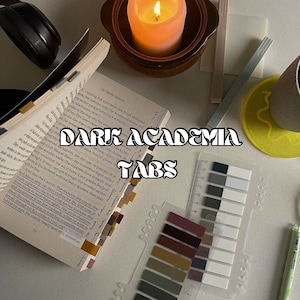 Könnte beinhalten: Ein Stillleben mit einem Buch mit farbigen Lesezeichen, einer brennenden Kerze und Haftnotizen. Der Text "DARK ACADEMIA TABS" ist zu sehen. Die Szene vermittelt eine gemütliche, studienorientierte Ästhetik.