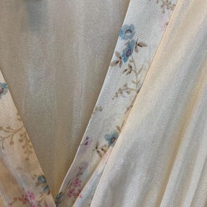 May include: A white, sheer, floral-patterned nightgown with a V-neckline. The fabric is made of 100% nylon and is machine washable at low speed.