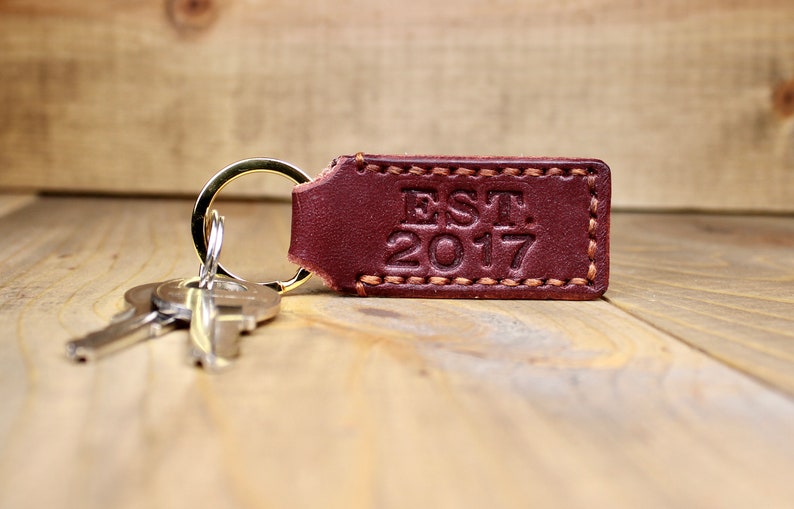 Burgundy leather keychain with brown thread and gold keyring. Personalized with "EST. 2017"