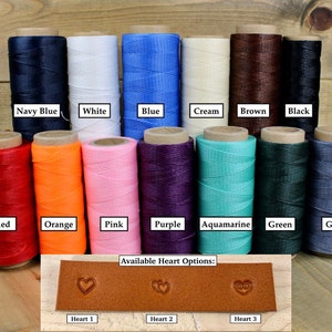 Peut inclure: Un assortiment de 12 bobines de fil cir&eacute; de diff&eacute;rentes couleurs, notamment bleu marine, blanc, bleu, cr&egrave;me, marron, noir, rouge, orange, rose, violet, aigue-marine, vert et gris. Les bobines sont dispos&eacute;es en deux rang&eacute;es de six. En dessous des bobines se trouve un &eacute;chantillon de cuir avec trois tampons en forme de c&oelig;ur diff&eacute;rents. Le texte "Available Heart Options:" est au-dessus de l'&eacute;chantillon de cuir. Le texte "Heart 1", "Heart 2" et "Heart 3" est en dessous de l'&eacute;chantillon de cuir.