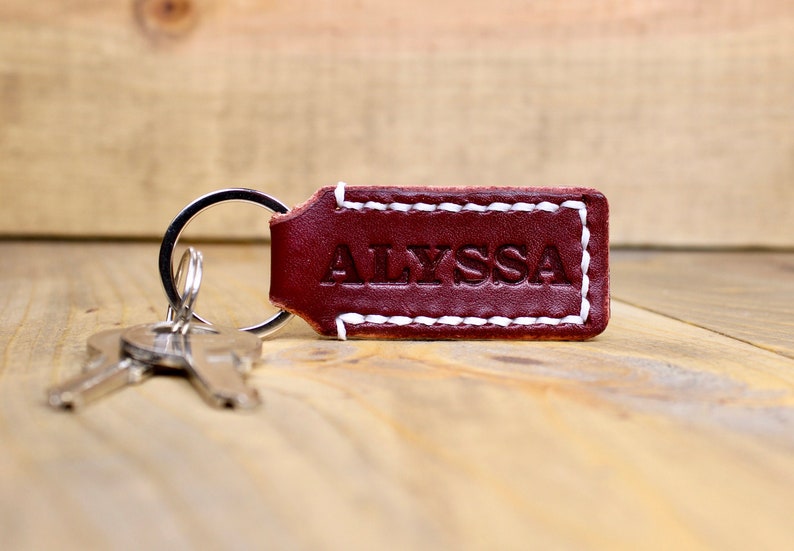 Burgundy leather keychain with white thread and silver keyring. Personalized with "ALYSSA"