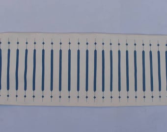 May include: A white runner rug with a repeating pattern of dark blue vertical lines and diamond shapes.