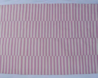 May include: Pink and white striped rug with a woven texture. The rug has a fringe border.