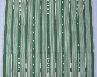 May include: A green and white striped rug with a geometric pattern. The rug has a fringed border.