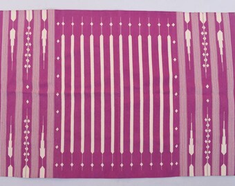 May include: A pink and white striped rug with a geometric pattern. The rug has a fringe border.
