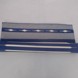 Peut inclure: Un tapis bleu et blanc ray&eacute; enroul&eacute; avec un motif g&eacute;om&eacute;trique. Le tapis est en coton et est parfait pour ajouter une touche de style &agrave; n'importe quelle pi&egrave;ce.