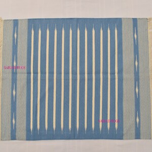 May include: A rectangular blue and white striped rug with fringed edges. The rug features vertical cream-colored stripes against a blue background. The design includes decorative elements and the text "SAHJAD RUGS".