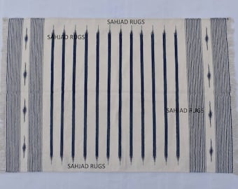 Puede incluir: Una alfombra de rayas blancas y negras con flecos en todos los lados. La alfombra tiene un patrón geométrico y el texto "SAHJAD RUGS" está impreso en la alfombra.