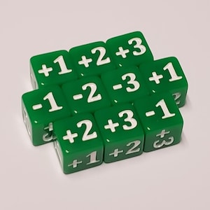 May include: Nine green dice with white numbers. The dice have the following numbers: +1, +2, +3, -1, -2, -3, +1, +2, +3.