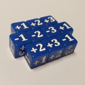 Könnte beinhalten: Ein Satz von neun blauen Würfeln mit weißen Zahlen. Die Würfel sind in einem 3x3-Raster angeordnet. Die Zahlen auf den Würfeln sind +1, +2, +3, -1, -2, -3, +1, +2 und +3.