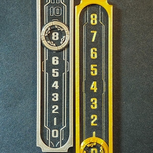 Puede incluir: Dos paneles rectangulares numerados. Uno es plateado con n&uacute;meros negros y un dise&ntilde;o circular con el n&uacute;mero 8. El otro es dorado con n&uacute;meros negros y un dise&ntilde;o circular con el n&uacute;mero 0.