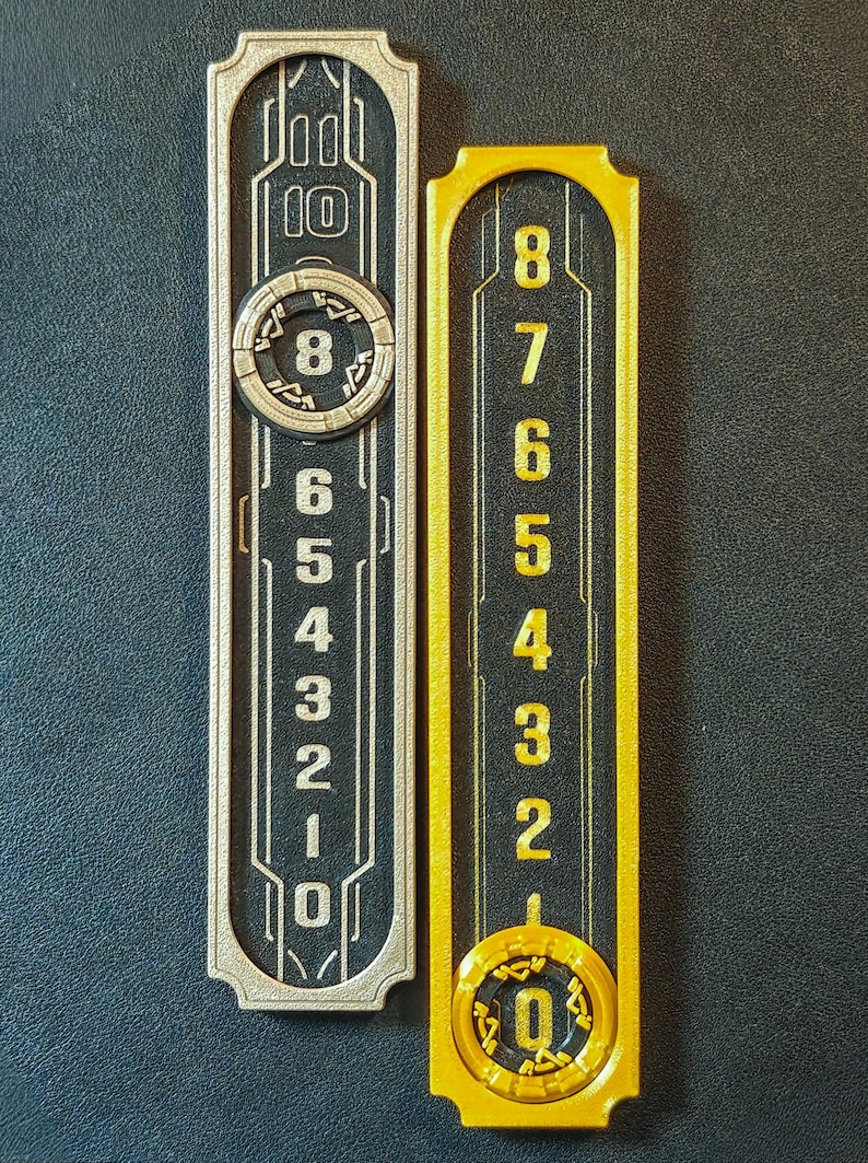 Puede incluir: Dos paneles rectangulares numerados. Uno es plateado con n&uacute;meros negros y un dise&ntilde;o circular con el n&uacute;mero 8. El otro es dorado con n&uacute;meros negros y un dise&ntilde;o circular con el n&uacute;mero 0.