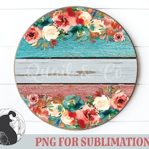 May include: Round wooden sign with a distressed blue, gray, and red paint finish. The sign is decorated with a floral wreath of watercolor roses and greenery. The text "Quail & Co." is written in white on the gray section of the sign.