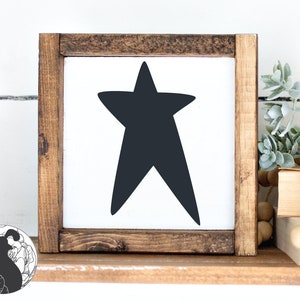 May include: A wooden framed sign with a black star shape on a white background.