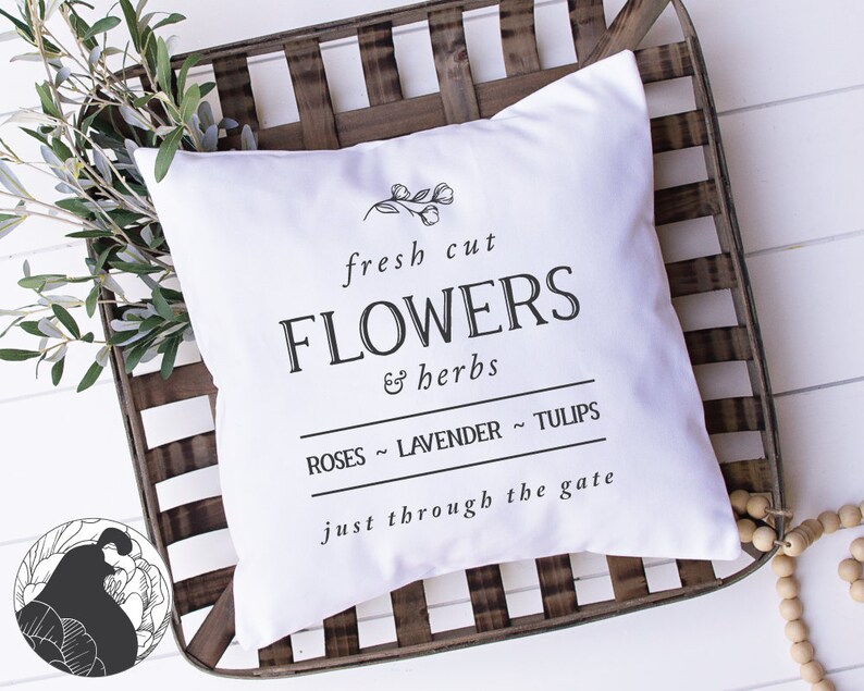 May include: White pillow with black text that reads "fresh cut FLOWERS & herbs ROSES ~ LAVENDER ~ TULIPS just through the gate". The pillow is sitting on a wooden crate.