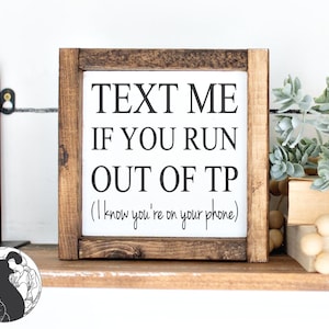 Puede incluir: Un letrero de madera con el texto "TEXT ME IF YOU RUN OUT OF TP (I know you're on your phone)".