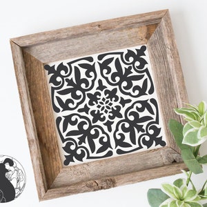 May include: Black and white geometric tile design framed in a rustic wood frame. The tile features a repeating pattern of intricate floral motifs.