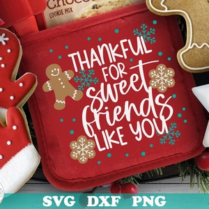 May include: A festive image with a red oven mitt, decorated with gingerbread men and snowflakes, bearing the text "Thankful for Sweet Friends Like You." Includes gingerbread and star-shaped biscuits, and a red and black plaid bow.