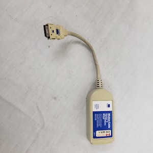 May include: A beige 3Com Modem Cable with a black connector and a blue and white label. The label reads "Modem Cable Ethernet LAN-28 Modem PC Card". The cable has a Canadian flag sticker.